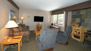 A living room with a sofa, two armchairs, a coffee table, a TV, and a fireplace. - Mammoth Ski & Racquet Club #94, 2 bedroom Dog Friendly (Mammoth Lakes)