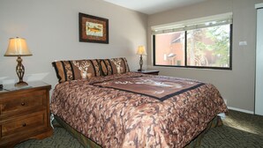 A bedroom with a bed, two bedside tables with lamps, a window with blinds, and a framed picture on the wall. - Mammoth Ski & Racquet Club #94, 2 bedroom Dog Friendly (Mammoth Lakes)