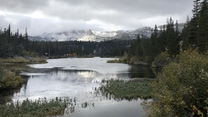 A natural landscape with a lake surrounded by dense forest and snow-capped mountains in the background. - Mountainback #12, 2 Bdrm, 3 Ba, Loft - Pet OK (Mammoth Lakes)