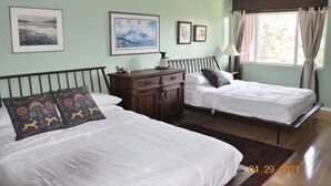 Une chambre avec deux lits, une commode et une fenêtre avec des rideaux.