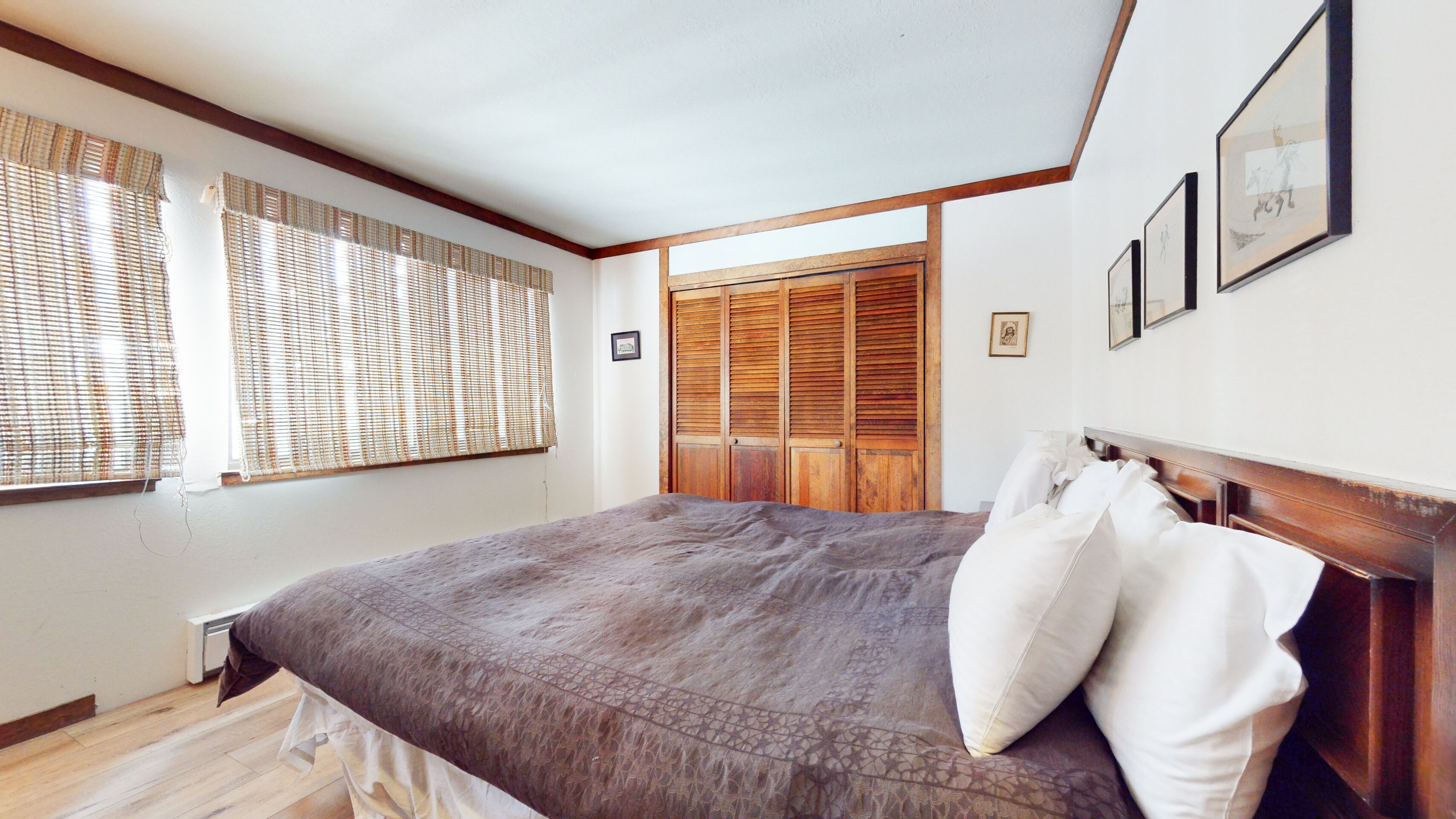 Un dormitorio con una cama grande, cabecera de madera y un armario con espejo.