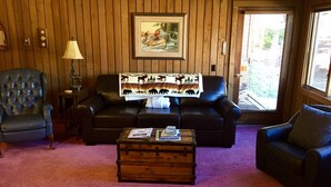 A living room with a leather sofa, a wooden coffee table, and a framed picture on the wall. - Mountainback #74 2 Bedroom 2 Bath (Mammoth Lakes)