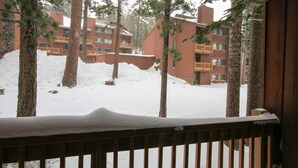 A view of a building with multiple floors and balconies, surrounded by trees and covered in snow. - Mammoth Ski & Racquet Club #25 (Mammoth Lakes)