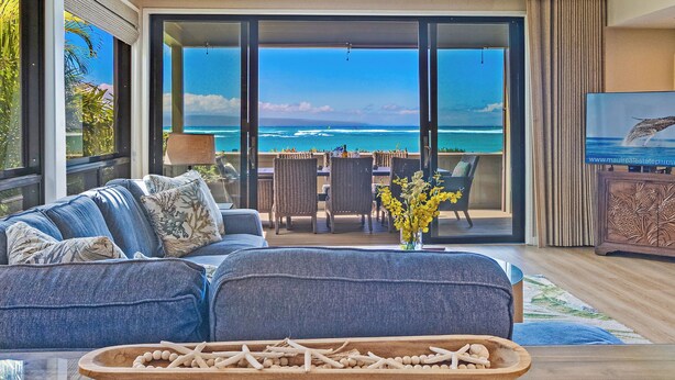 Ein Wohnzimmer mit einer Couch, einem Esstisch und Meerblick.