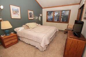 A bedroom with a bed, bedside table, lamp, TV, and framed pictures on the wall. - Mountainback #53, Loft (Mammoth Lakes)