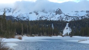 Un riu envoltat de muntanyes nevades i boscos densos.