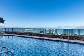 A swimming pool with a view of the ocean and a stone wall. - Direct Oceanfront • AC • Top Floor Views • Peaceful West Maui (Kahana)