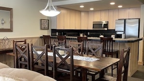 A modern kitchen with wooden cabinets, a central island, and stainless steel appliances. - Mountainback #57, Den (Mammoth Lakes)