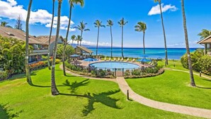 Un resort con piscina, palmeras y vista al océano.