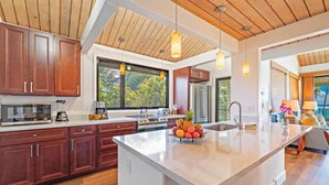 Una cocina moderna con armarios de madera, una isla grande y vistas al exterior.