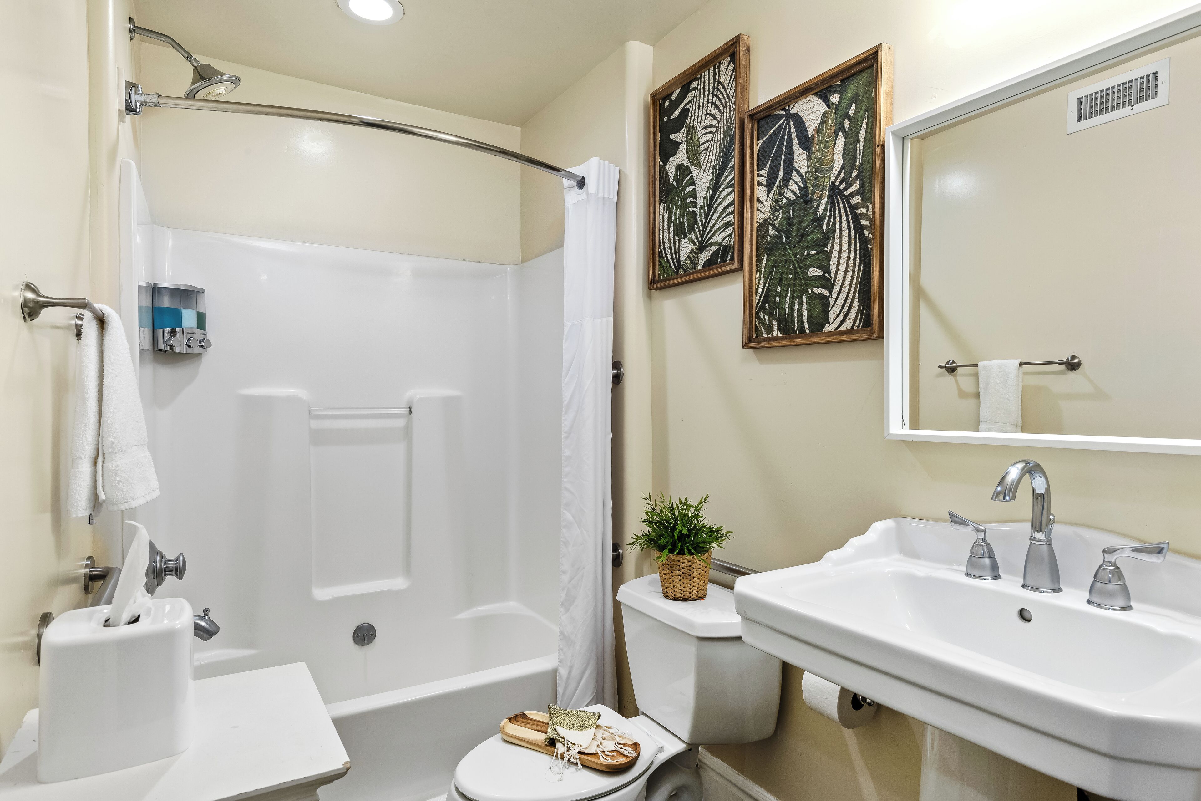Une salle de bain équipée d’une baignoire, de toilettes, d’un lavabo et d’un rideau de douche.