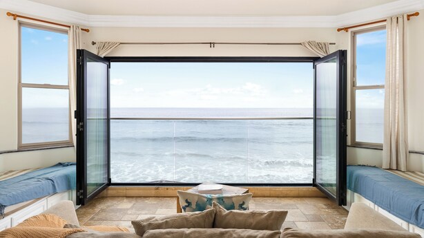 A room with a large glass door leading to a balcony overlooking the sea. - Luxurious Single Family Pet Friendly Oceanfront Home with Two Spas P825-X (Oceanside)