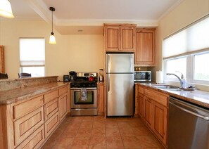 A kitchen with wooden cabinets, stainless steel appliances, and a window providing natural light.