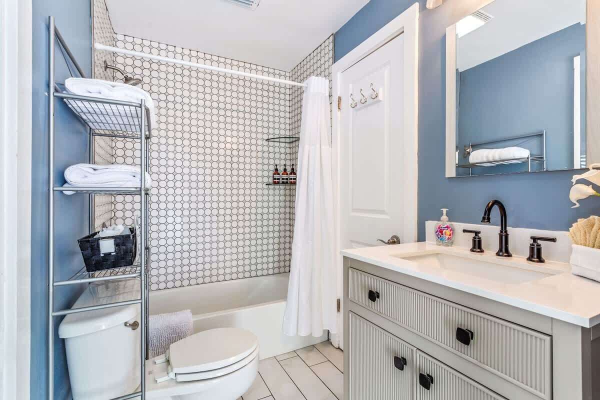Une salle de bain comprenant des toilettes, un lavabo, une douche et un porte-serviettes.