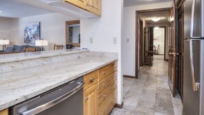 Una cocina moderna con encimeras de granito, gabinetes de madera y electrodomésticos de acero inoxidable.