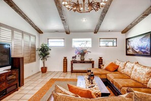 A living room with a television, sofa, coffee table, and decorative items. - Vineyard Views + Jetted Tub | Paso Robles Wine Country | Solitude I (Paso Robles)
