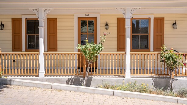 A two-story building with a covered porch, wooden shutters, and a numbered address. - 2 Ensuite Suites + Walk to Downtown | Paso Robles | Lewis Loft (Paso Robles)
