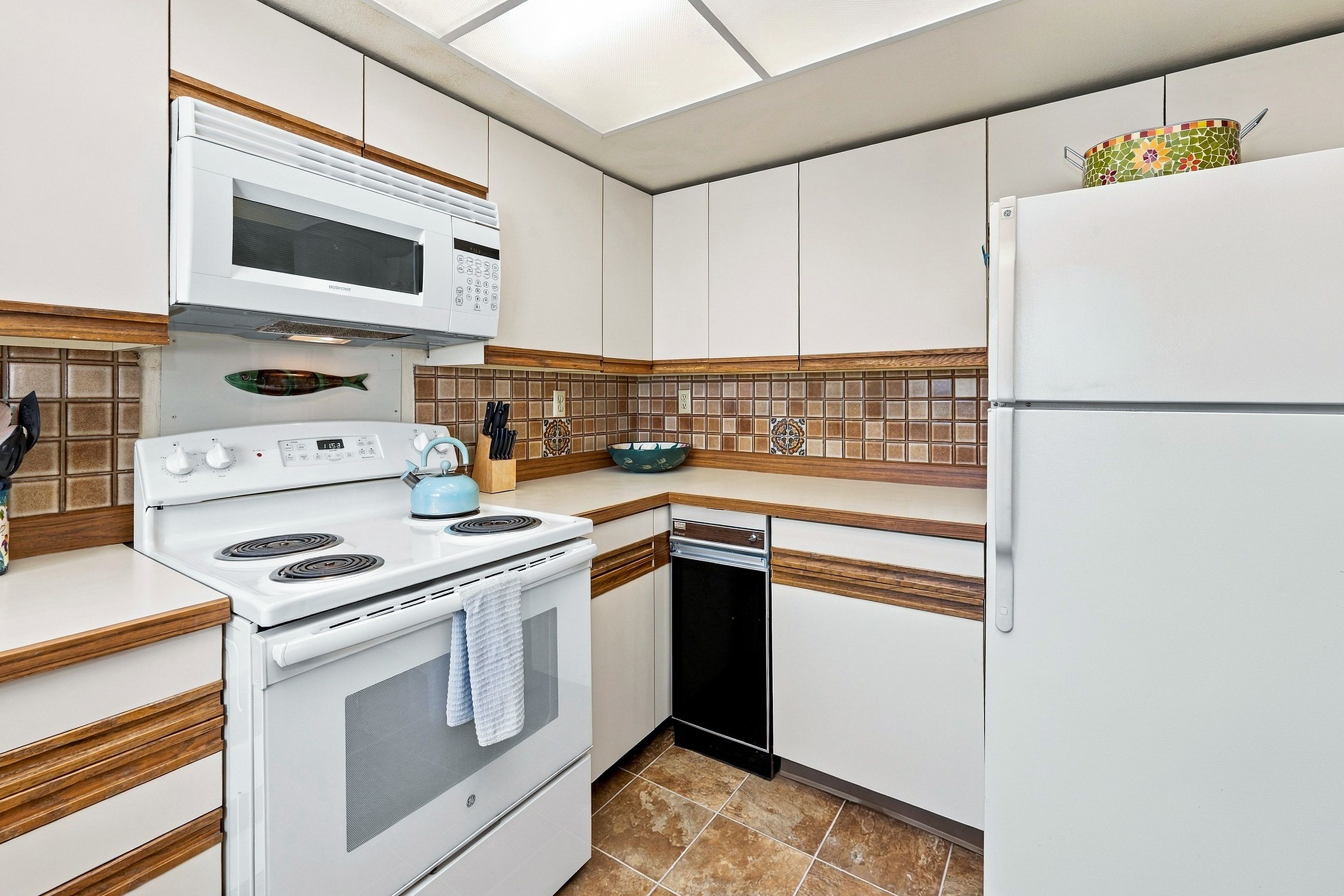 A kitchen with white appliances, a microwave, a stove, and a dishwasher.