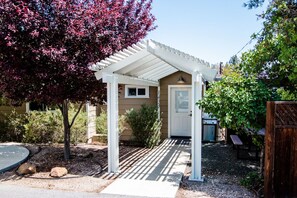 A covered porch with a white roof, a door, and a small window.