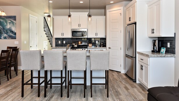 A modern kitchen with white cabinets, stainless steel appliances, and a central island with bar stools. - Spacious 3BR Sleeps 10 - Poolside on the 9th Hole (St. George)