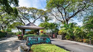 Cartell de Kona Bay Estates amb una glorieta i paisatgisme tropical.