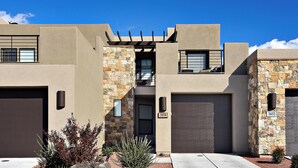 A modern two-story house with a stone facade, a garage, and a well-maintained front yard with landscaping.