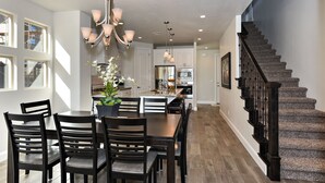 A spacious kitchen with white cabinets, a central island, and a modern chandelier. - Spacious 4BR on the 9th - Overlooks Pool & Courts (St. George)