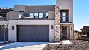 A modern two-story house with a garage, a balcony, and a stone pillar. - Spacious 4BR on the 9th - Overlooks Pool & Courts (St. George)