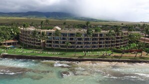 A hotel with a circular layout, multiple floors, and a pool area with sun loungers.
