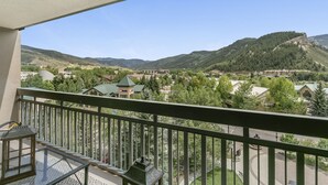 A balcony with a view of a mountainous landscape, a building with a green roof, and a clear sky. - Gorgeous Views of Vail and Beaver Creek A702 (Avon)