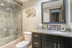 Een bad/douchecombinatie, een haardroger, handdoeken