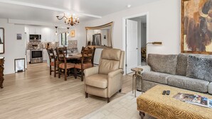 A spacious living room with a sofa, a chair, a coffee table, and a dining area with chairs and a table. - Gorgeous Views of Vail and Beaver Creek A702 (Avon)