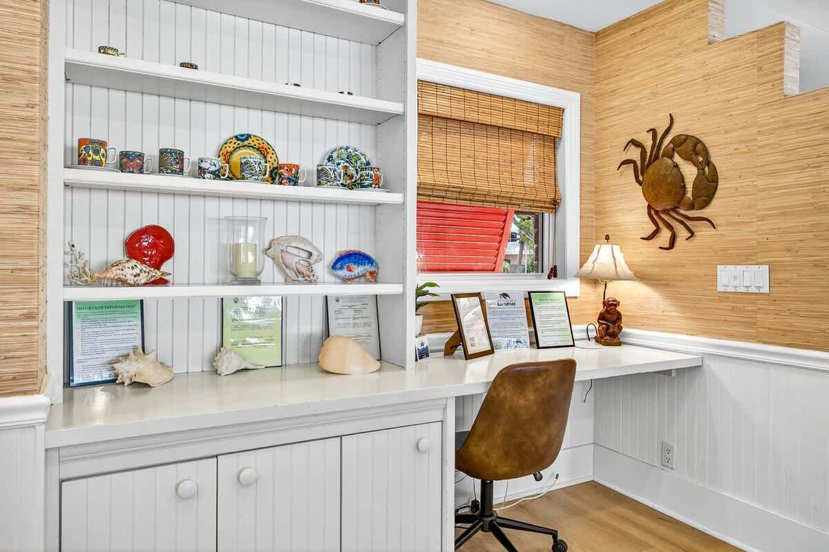 A kitchen with white cabinetry, a wooden accent wall, and a crab decoration.