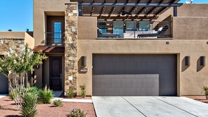 A modern two-story house with a stone facade, a garage, and a covered outdoor seating area. - Sleeps 17 w/ Pergola Lounge, Fire Pit & Pool View (St. George)