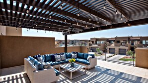 An outdoor patio with a sectional sofa, a coffee table, and a ceiling fan. - Sleeps 17 w/ Pergola Lounge, Fire Pit & Pool View (St. George)