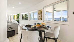 A dining area with a round table, chairs, and a view of the sea. - Florida Villa - Waterfront - Private Pool! (Crystal Beach)