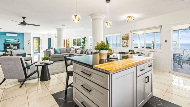 A modern kitchen with a central island, pendant lighting, and a view to the outside. - Florida Villa - Waterfront - Private Pool! (Crystal Beach)