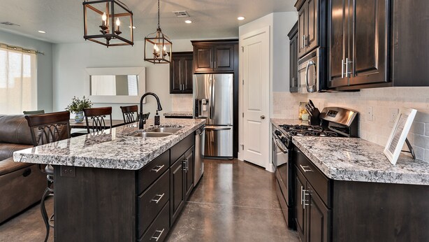 A modern kitchen with dark cabinetry, a granite countertop, stainless steel appliances, and pendant lighting. - Stylish 4BR on the 18th - Rooftop Deck, Near Pool (St. George)