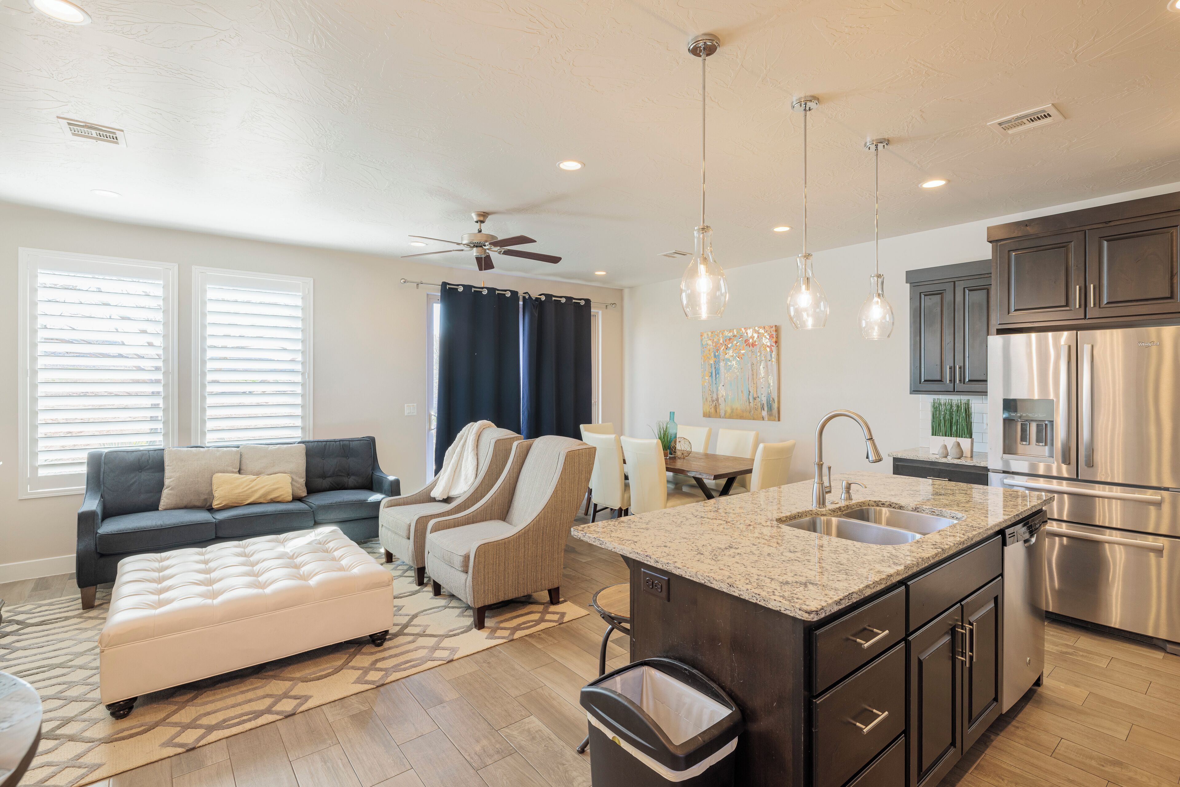 A modern kitchen with a central island, stainless steel appliances, and pendant lighting.