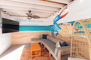 A cozy room with a sofa, a small table, and a mural of a crab.