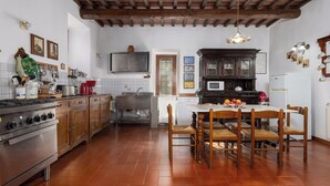 Una cucina con piano cottura, lavello e zona pranzo con sedie.