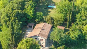 Un edificio in pietra con tetto in tegole, immerso nel verde.
