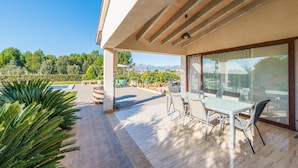 A modern outdoor patio with a dining table and chairs, a pool, and a view of mountains and greenery. - ES SERRAL - Villa with private pool in sa Pobla. Free WiFi (Sa Pobla)