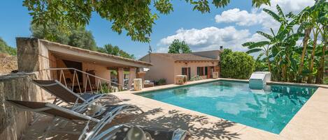 A swimming pool with lounge chairs and a concrete structure.