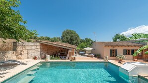 A clear blue pool with steps leading into it, surrounded by a patio area with outdoor furniture and a building with a tiled roof. - ALCUDIOLA - Villa with private pool in Santa Margarita. Free WiFi (Santa Margalida)