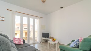 A living room with a sofa, a green armchair, a television on a stand, and a small table with a fruit bowl. - CA NA MARIA (DORANT) - Chalet with terrace in Son Serra de Marina. (Santa Margalida)