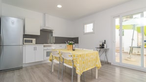 A modern kitchen with white cabinets, a microwave, and a dining table with chairs. - CA NA MARIA (DORANT) - Chalet with terrace in Son Serra de Marina. (Santa Margalida)