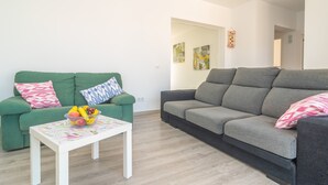 A living room with two sofas, a coffee table with fruit, and a door leading to another room. - CA NA MARIA (DORANT) - Chalet with terrace in Son Serra de Marina. (Santa Margalida)