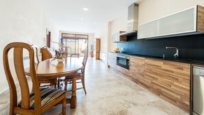A modern kitchen with wooden cabinetry, a built-in oven, and a black countertop. - CAS PEIX - ADULTS ONLY  - Villa with private pool in Sa Pobla. Free WiFi (Sa Pobla)