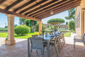 An outdoor patio with a stone floor, a wooden pergola, and a dining table set for six. - CAN CIREROL - Villa with private pool in Porto Colom- Felanitx. Free WiFi. (Portocolom)